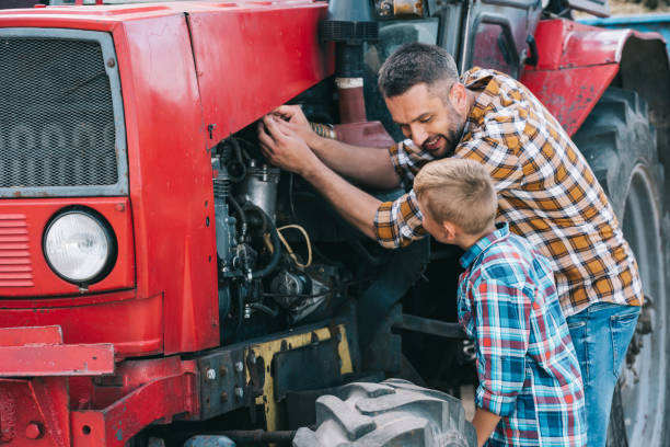 happy father and son repairing tractor engine together