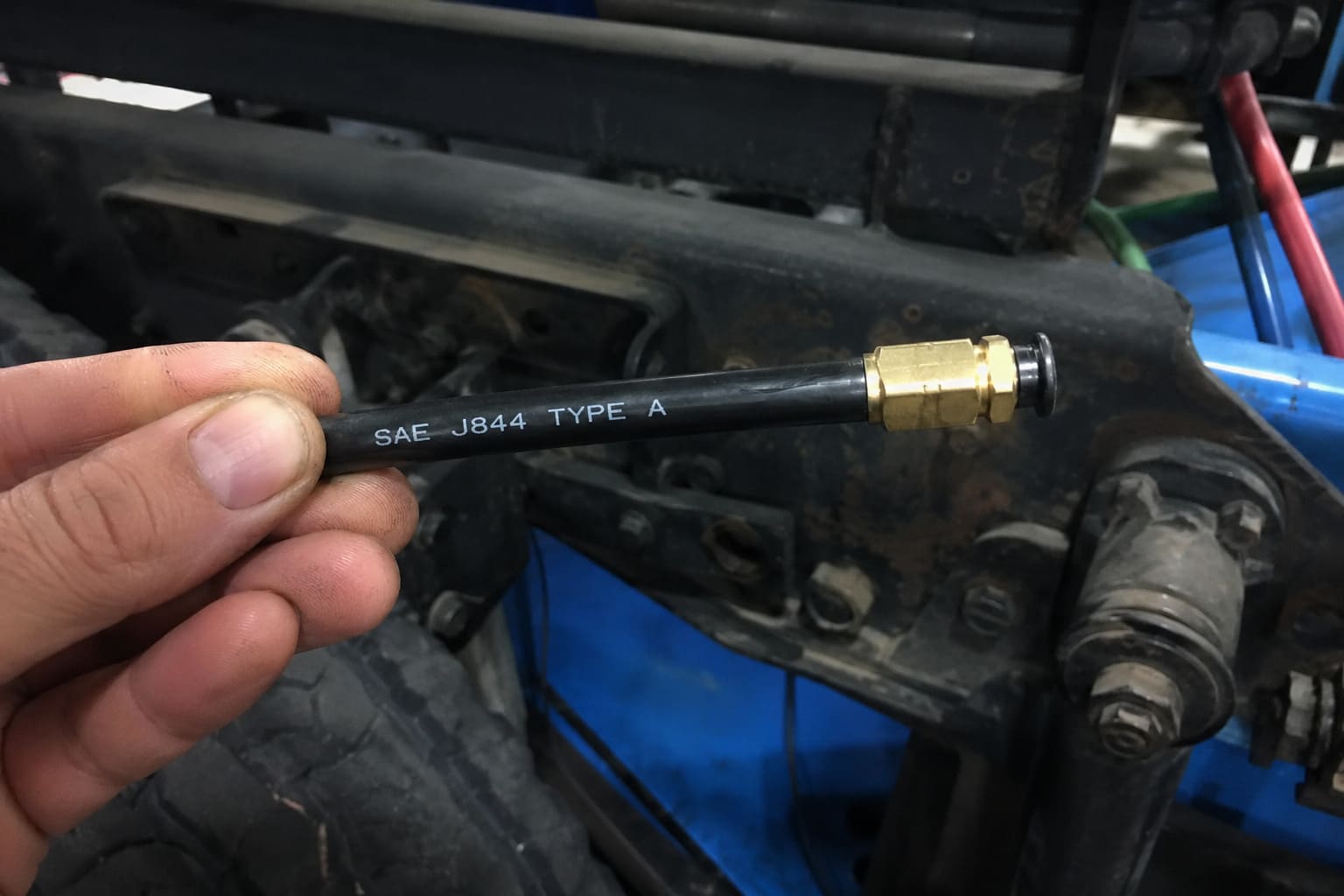 SAE J844 Type A marking on air brake tubing close-up of sae j844 type a marking printed on black nylon tubing next to a brass fitting